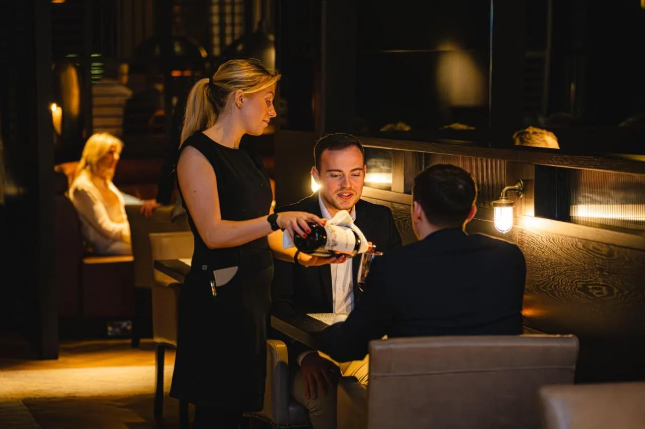 a woman is standing next to a man in a bar at Dakota Newcastle in Newcastle upon Tyne